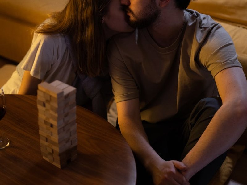 A man and a woman sitting together cuddling on the floor