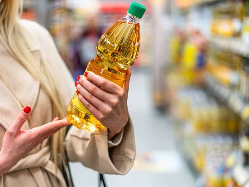 Lady carrying cooking oil in a store generic image