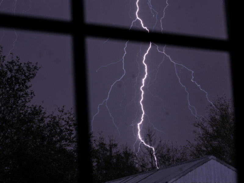 Lightning bolt seen outside a window