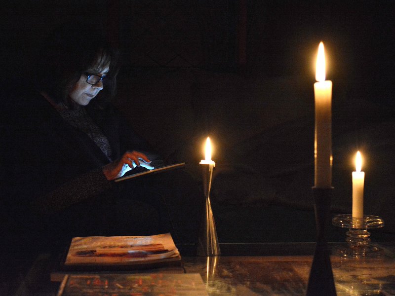 Woman reading book with candles