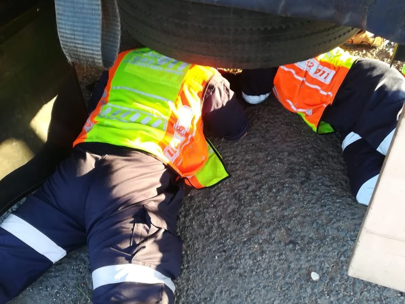 Medics try to free man trapped under truck
