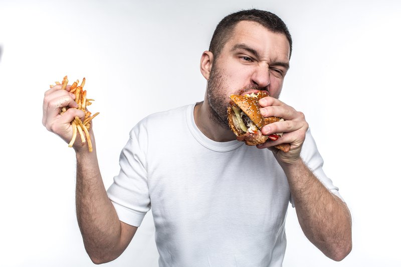 Man eating burger and chips