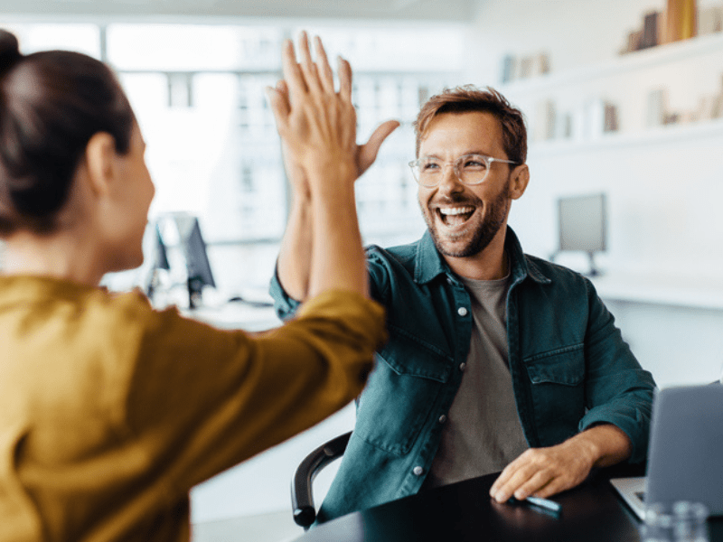 Man and woman high five in the office