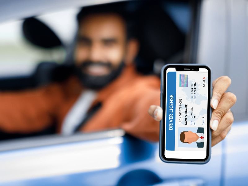 man holding phone showing driving licence card