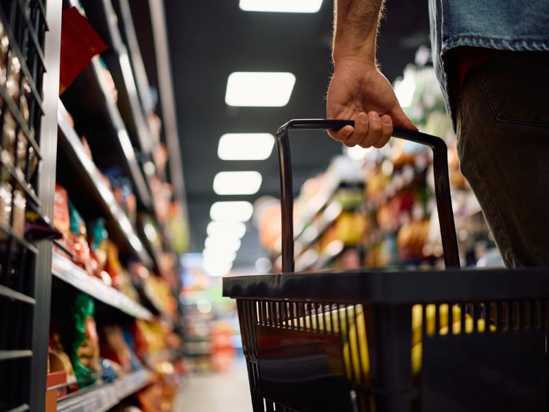 Close up of man with shopping basket buying groceries at the store