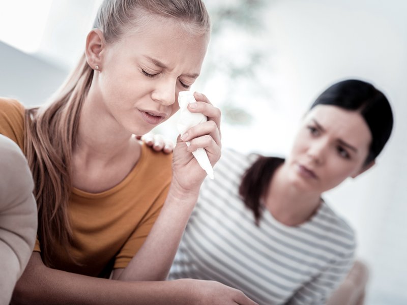 Mother comforting crying teenager