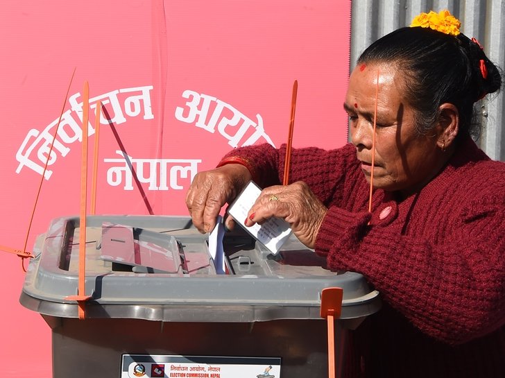 A Nepali voter casts her vote at a polling station in Chautara, east of the capital Kathmandu, on November 26, 2017.