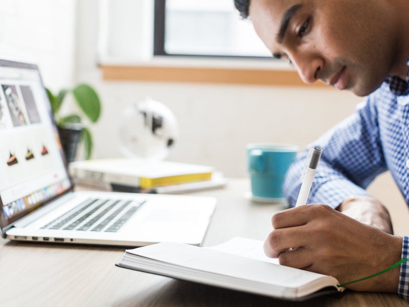 man writing with his left hand