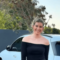 Rachel Kolisi posing next to a white Mercedes