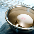 Single egg with an expiration date in a silver bowl