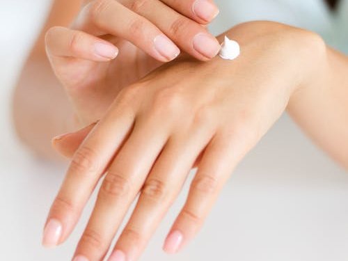 Woman applying lotion on hand