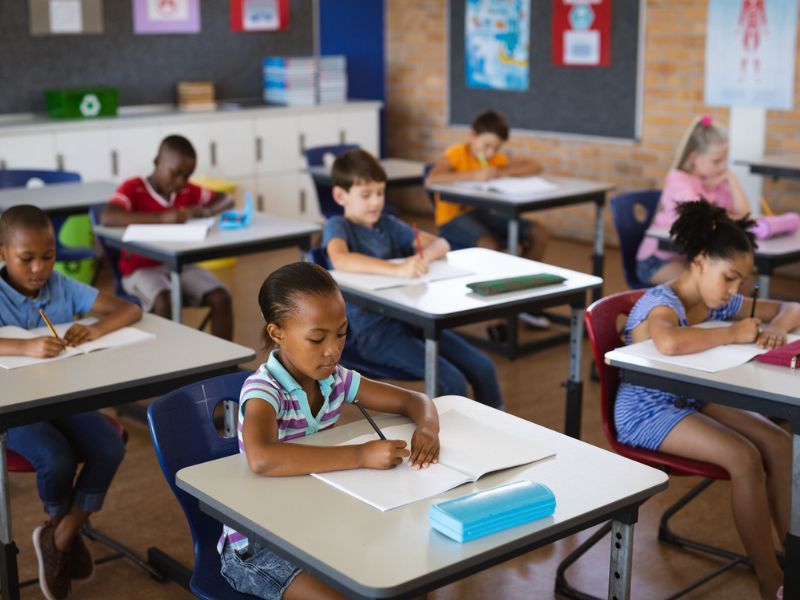 Students studying while sitting at their desks in the class