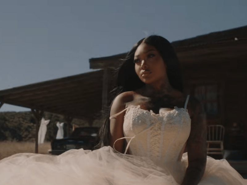 Summer Walker wearing a white lace wedding style dress with a full tulle skirt