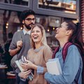 Three happy students talking on the street
