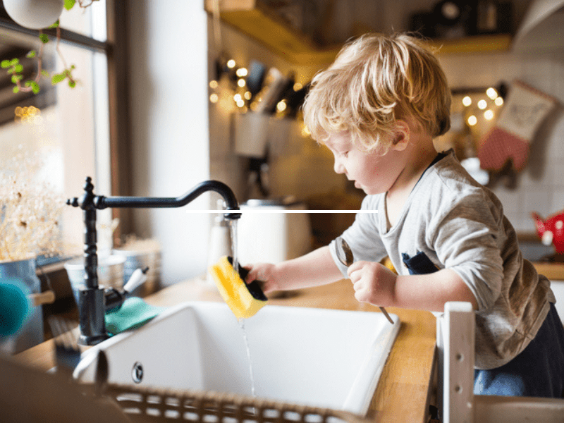 toddler boy washing the dishes