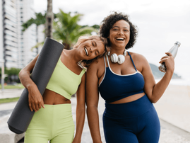 two  fitness women standing on the beach promenade