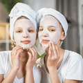 Two girls wearing a white face mask and towels on their head