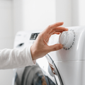 Female hand chooses washing machine mode