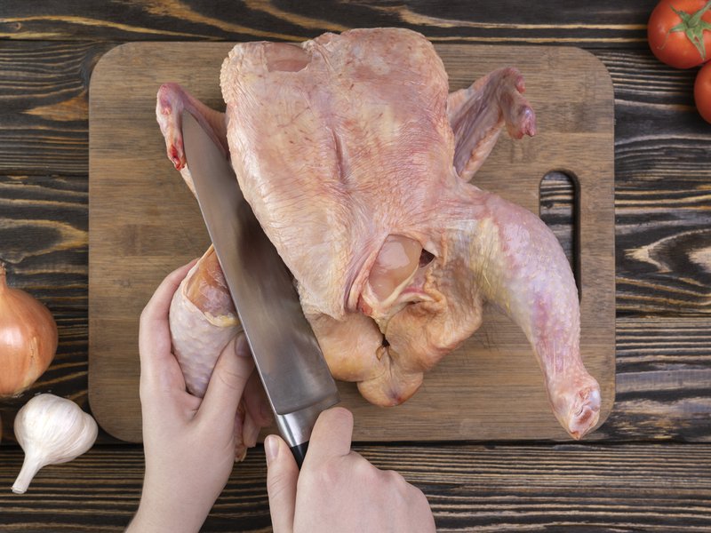 Woman cutting chicken