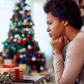 woman deep sits near a christmas tree