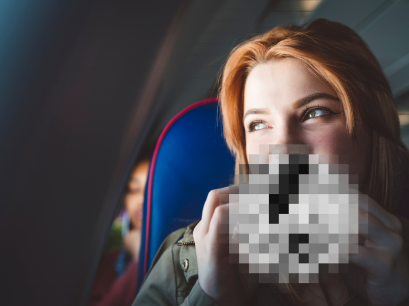 Woman eating on a plane blurred out