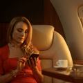 woman looks at her phone while sitting in first class