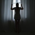 woman opening curtains