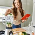 woman puts spinach in a blender while busy in the kitchen-min.png