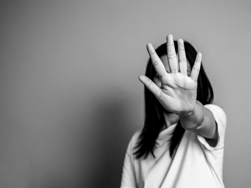 woman raising hand against abuse