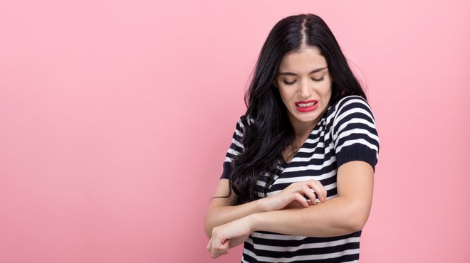 Woman scratching her itchy arm