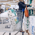 woman shopping in grocery store for toilet paper