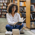 woman sits on the floor while reading books in a library