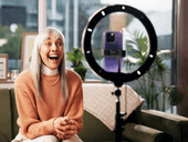 Mature woman content creator with smartphone and ring light