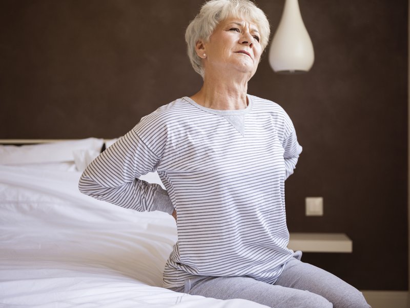 Woman sitting on an uncomfortable bed