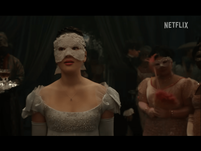 Woman wearing a silver gown and mask