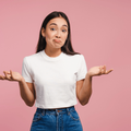 Confused young woman shrugging shoulders