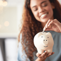 woman holding a piggybank deposits coin as savings
