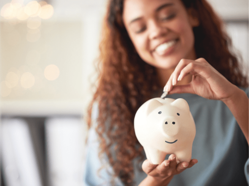 woman holding a piggybank deposits coin as savings